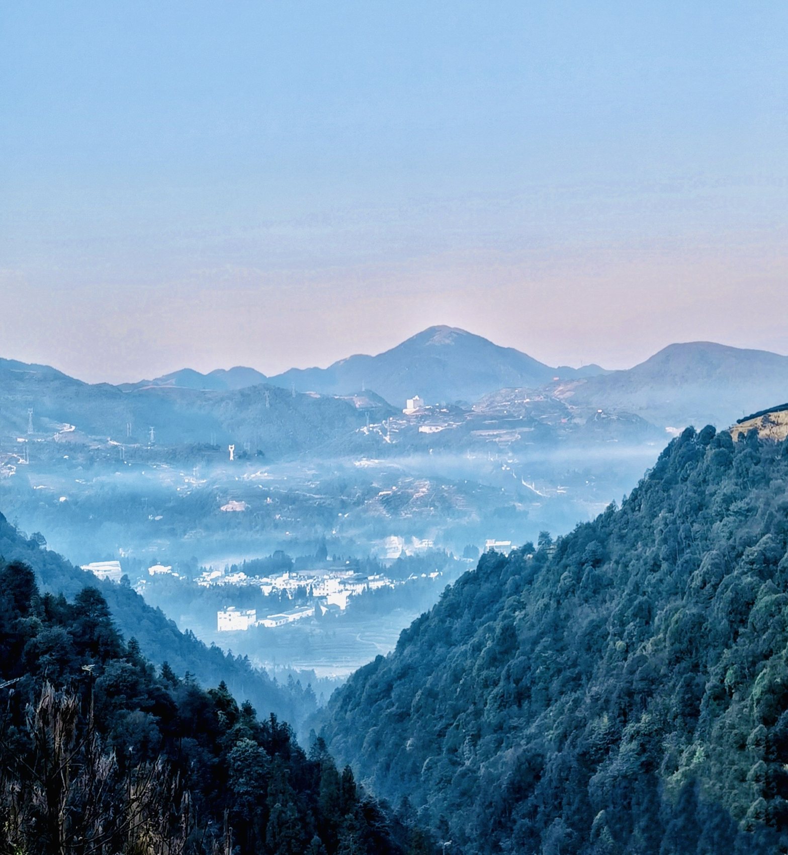 Layered blue mountains in mist at dusk