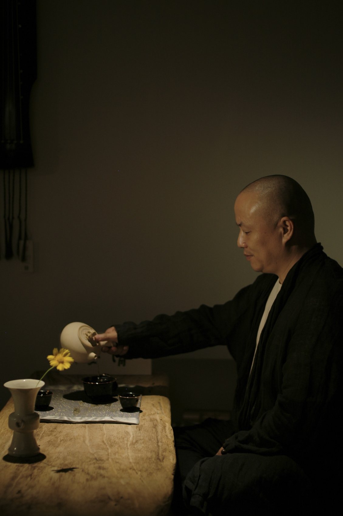 Ernan pouring tea at a dark table