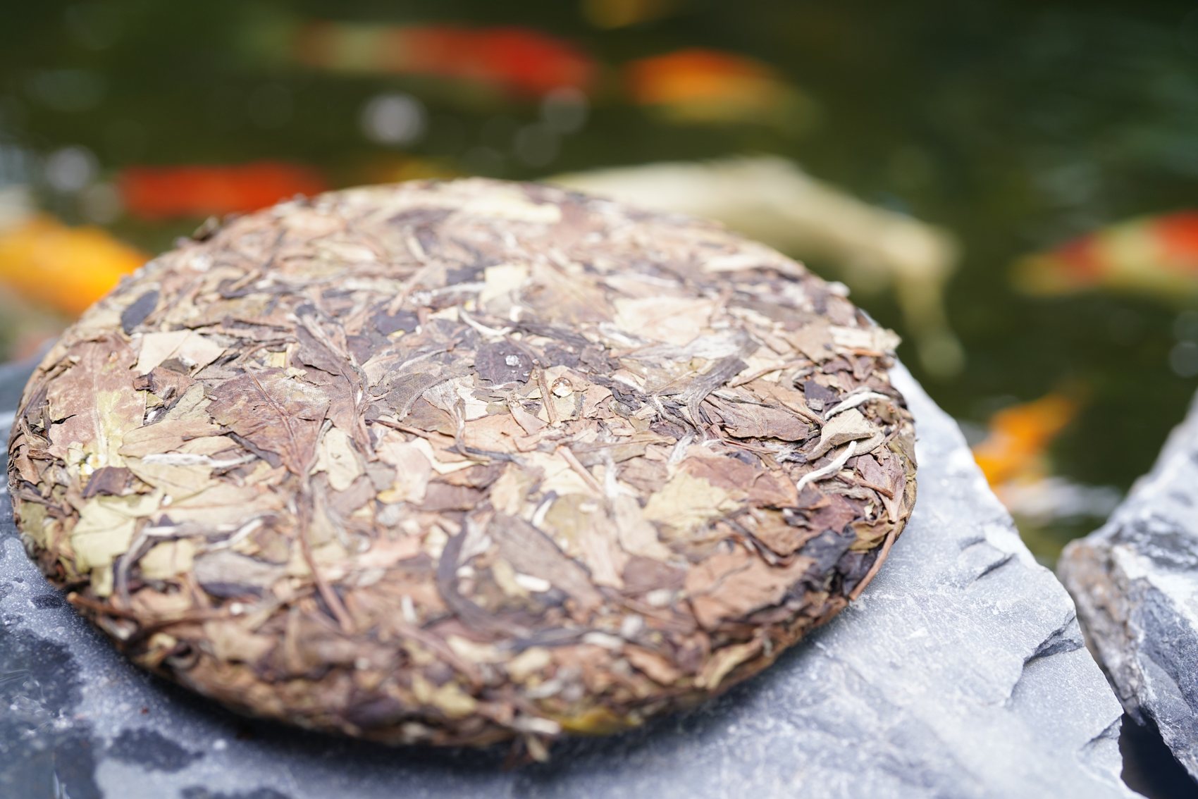 A pressed white tea cake resting on a banana leaf