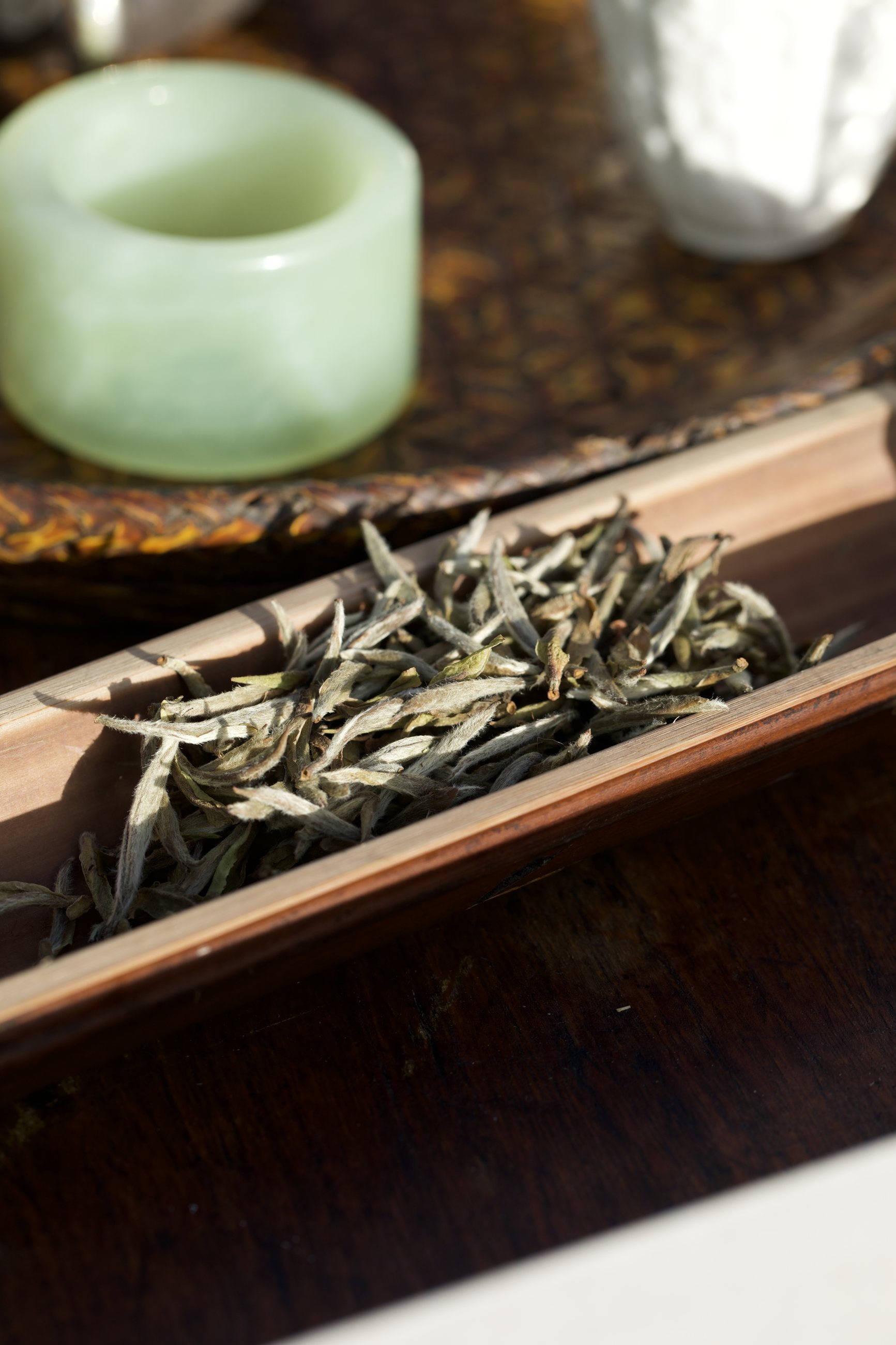 A calligraphy-labelled tea chest on a low table before green fields